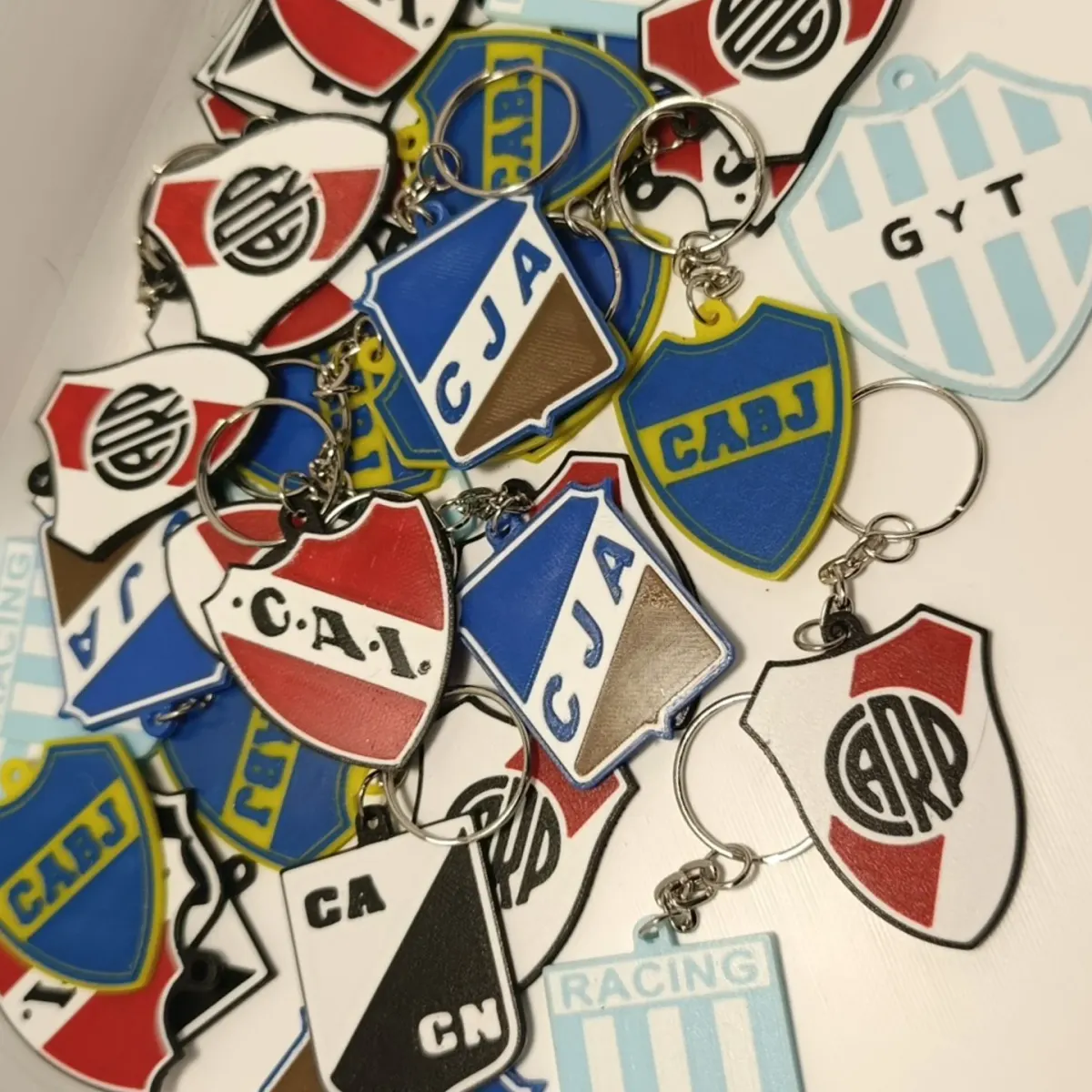 Pila de llaveros de escudos de fútbol impresos en 3D